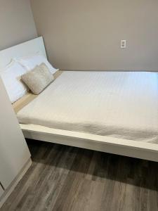 een bed in een kleine kamer met een wit matras bij Fully Furnished Hollywood, min 1 month stay, cozy unit in Hollywood