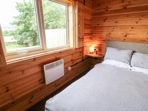 een slaapkamer met een bed in een houten hut bij Pheasant in Barnard Castle