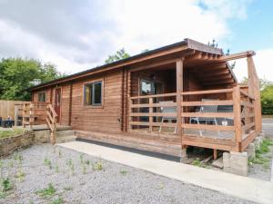 a log cabin with a porch and chairs in front of it at Pheasant in Barnard Castle