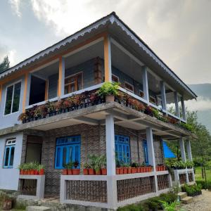 een huis met blauwe ramen en planten erop bij The Swarna Homestay in Darjeeling