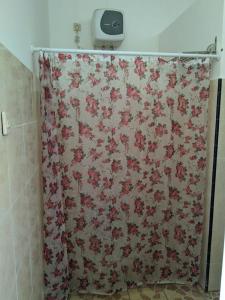 a shower curtain with a floral pattern in a bathroom at ANDY'S LODGE KELIMUTU in Kelimutu