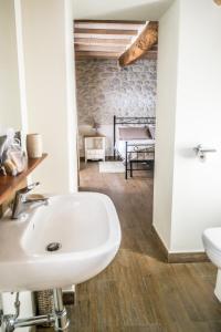 a bathroom with a sink and a toilet and a bedroom at Tenuta Gambit Agriturismo Umbria in Monteleone dʼOrvieto