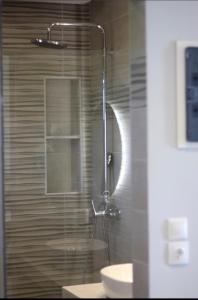 a shower with a glass door next to a sink at Family Studios in Marathias