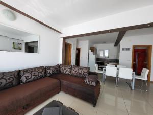 a living room with a brown couch and a dining room at Apartments Villa Natali - Heating Pool in Trogir