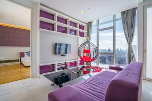 a living room with a purple couch and a large window at Yemala Suites at Platinum KLCC in Kuala Lumpur