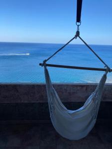 a hammock hanging from a wall overlooking the ocean at Porto Corallo Frontemare in Villaputzu