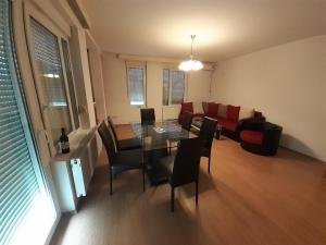 uma sala de estar com uma mesa e cadeiras e um sofá em Apartman Nole 1 em Despotovac