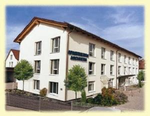 a large white building with a brown roof at Apartments Aschheim in Aschheim