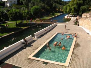 un gruppo di persone che giocano in piscina di Casa do Neveiro a Góis