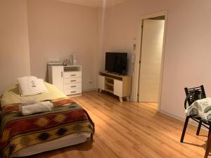 1 dormitorio con 1 cama, vestidor y TV en OASIS Centro Obelisco en Buenos Aires