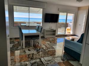 ein Wohnzimmer mit einem Tisch und Meerblick in der Unterkunft Ático frente al mar. Apartamento TOP in Oropesa del Mar