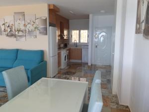 ein Wohnzimmer mit einem weißen Tisch und einem blauen Sofa in der Unterkunft Ático frente al mar. Apartamento TOP in Oropesa del Mar