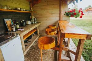 a wooden kitchen with a table and chairs in a cabin at Ezermala in Valdemārpils