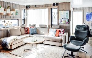 sala de estar con sofá, mesa y silla en Cozy Home In Sjusjen With Sauna, en Sjusjøen