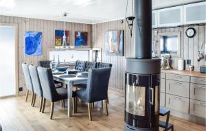 a kitchen with a dining room table with a wood stove at Cozy Home In Sjusjen With Sauna in Sjusjøen