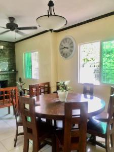 a dining room with a table and a clock on the wall at The Nook in Tagaytay