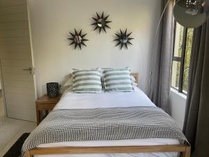 1 dormitorio con 1 cama con 2 relojes en la pared en PepperTree Guest House, en Johannesburgo