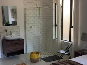 y baño con lavabo y ducha. en PepperTree Guest House, en Johannesburgo