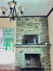 a stone fireplace with a tv on top of it at The Nook in Tagaytay