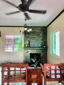 a living room with a ceiling fan and a fireplace at The Nook in Tagaytay