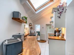 a kitchen with white walls and a skylight at Clover Neuk in Largs