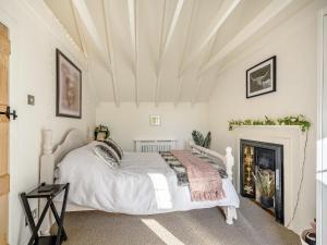 a bedroom with a white bed and a fireplace at Clover Neuk in Largs