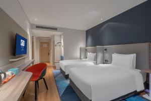 a hotel room with two beds and a red chair at Holiday Inn Express Lanzhou New Area, an IHG Hotel in Lanzhou