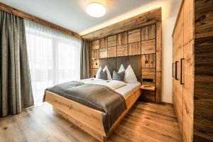 sypialnia z dużym łóżkiem i dużym oknem w obiekcie Ellmauer Hex Appartements w mieście Ellmau