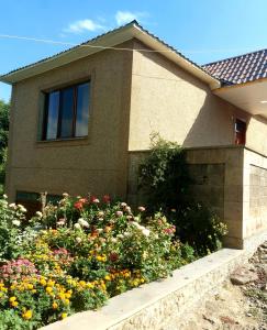 ein Haus mit einem Blumengarten davor in der Unterkunft D&G guest house in Yeghegnadzor