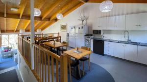 Baw Baw Village的住宿－Tanjil Creek Lodge，一间带2张桌子的厨房和一间带白色橱柜的厨房