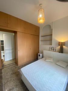 a bedroom with a large white bed and a chandelier at Nice port : cosy appartement au calme in Nice