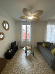 een woonkamer met een bank en een plafondventilator bij Nice port : cosy appartement au calme in Nice