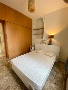 een slaapkamer met een groot wit bed in een kamer bij Nice port : cosy appartement au calme in Nice