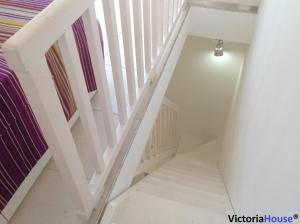 a white staircase with a white stair case at Victoria House Scopello in Scopello