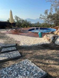 einen Pool mit einem Tisch und einem Sonnenschirm in der Unterkunft Lovin Gocek & Tiny house Mermaid in Fethiye
