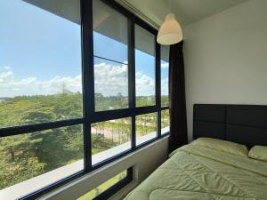 een slaapkamer met een bed en een groot raam bij ONE Homestay A 6Pax 2Rooms in Sibu