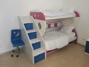 a bunk bed with a desk and a chair in a room at Talabay AQABA in Aqaba