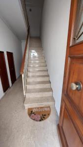 Una escalera que conduce a una habitación con puerta de madera en Appartamento Da Castlin en Fano