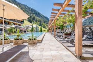 a resort with a swimming pool and a mountain at Hotel Weisses Lamm in See