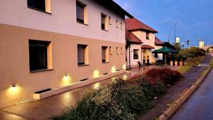 a building with lights on the side of a street at Guesthouse ob Sotočju Budič in Brežice