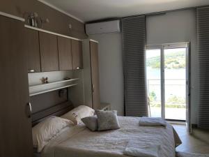 ein Schlafzimmer mit einem Bett mit Kissen und einem Fenster in der Unterkunft Villa Lana Apartments in Tisno