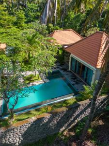 an overhead view of a swimming pool in front of a house at Coco Garden Pool Villas in Kubutambahan