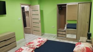 a bedroom with green walls and a bed and a mirror at Апартамент за гости Ива in Ruse