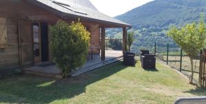 drewniany domek ze stołem i krzesłami na ganku w obiekcie Chalet au cœur du Val d'Azun w mieście Arras-en-Lavedan