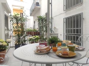 einen Tisch mit Tellern aus Essen auf einem Balkon in der Unterkunft La Casa sul Boulevard in Matera