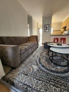 a living room with a couch and a table at Elegant 2 bed apartment next to Gautrain Centurion in Centurion