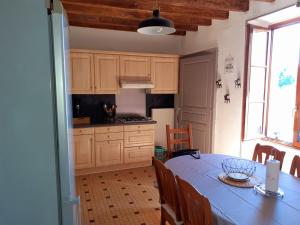 une cuisine avec une table et un chiffon bleu dans l'établissement LES AIRES AVOISIENNES, à Avoise
