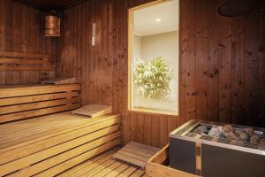 a room with a sauna with wooden walls and a window at Waldhotel Berghof Thüringer Wald in Luisenthal