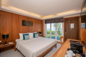 a hotel room with a bed and a window at Synergy Samui in Chaweng