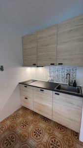 kuchnia z drewnianymi szafkami i zlewem w obiekcie Apartment Ginestra, Sella Nevea w mieście Sella Nevea +2 zdjęcia